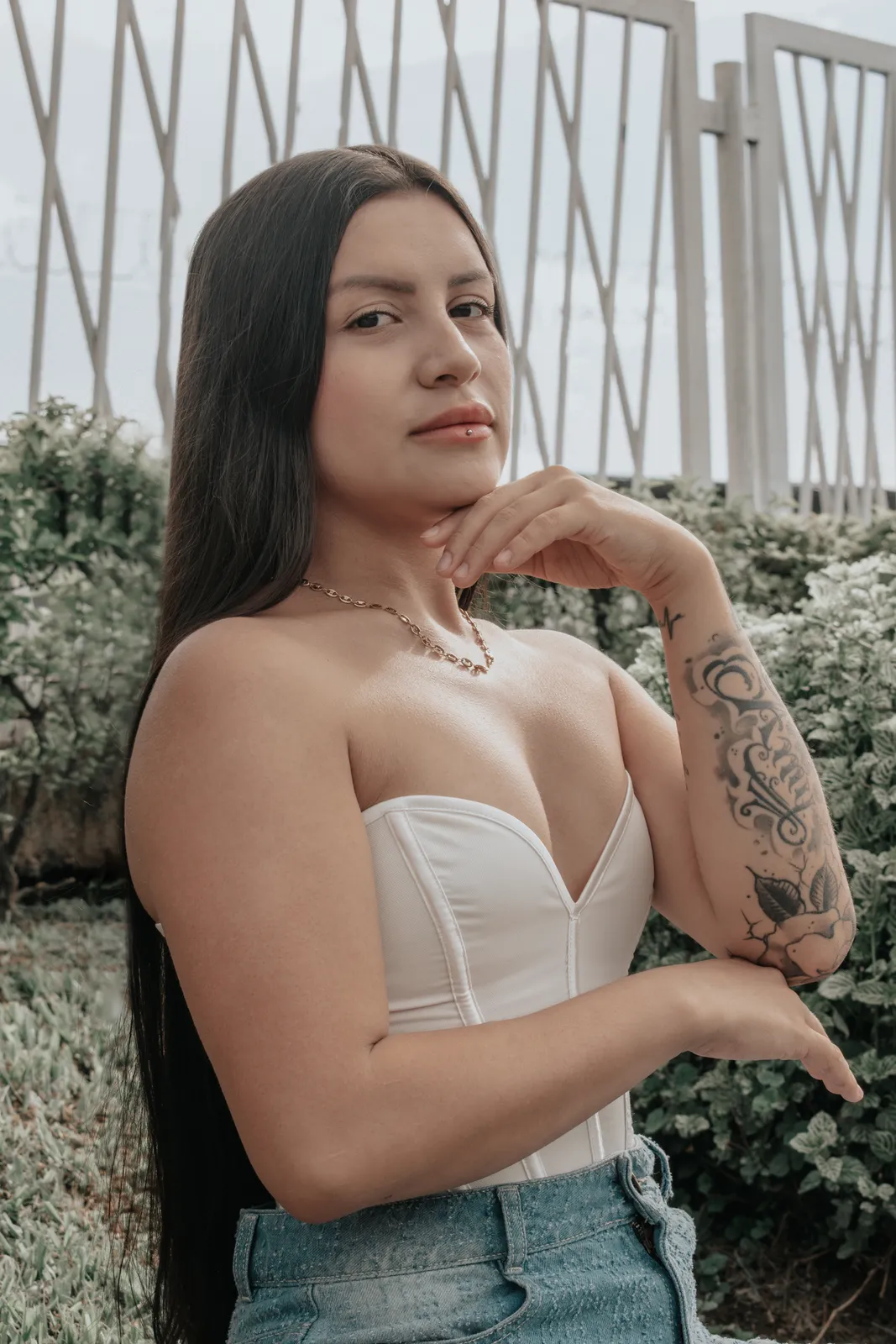 Retrato exterior de una mujer con corset blanco y tatuajes