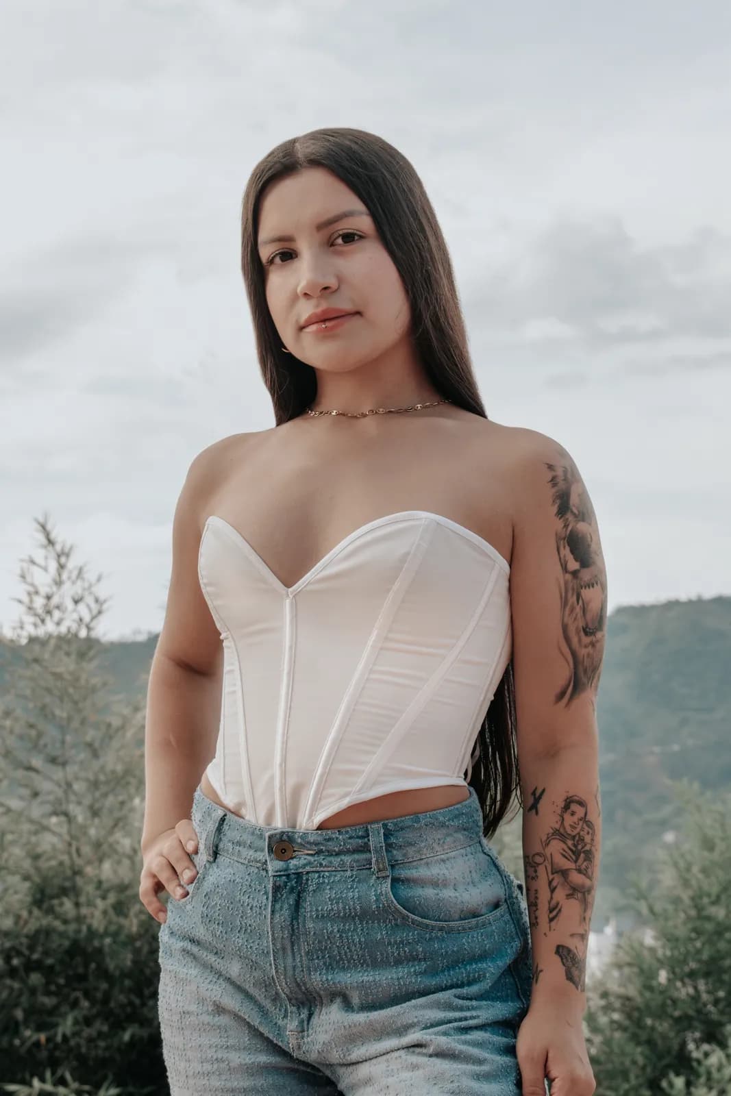 Retrato de cuerpo medio de una mujer con corset blanco y jeans