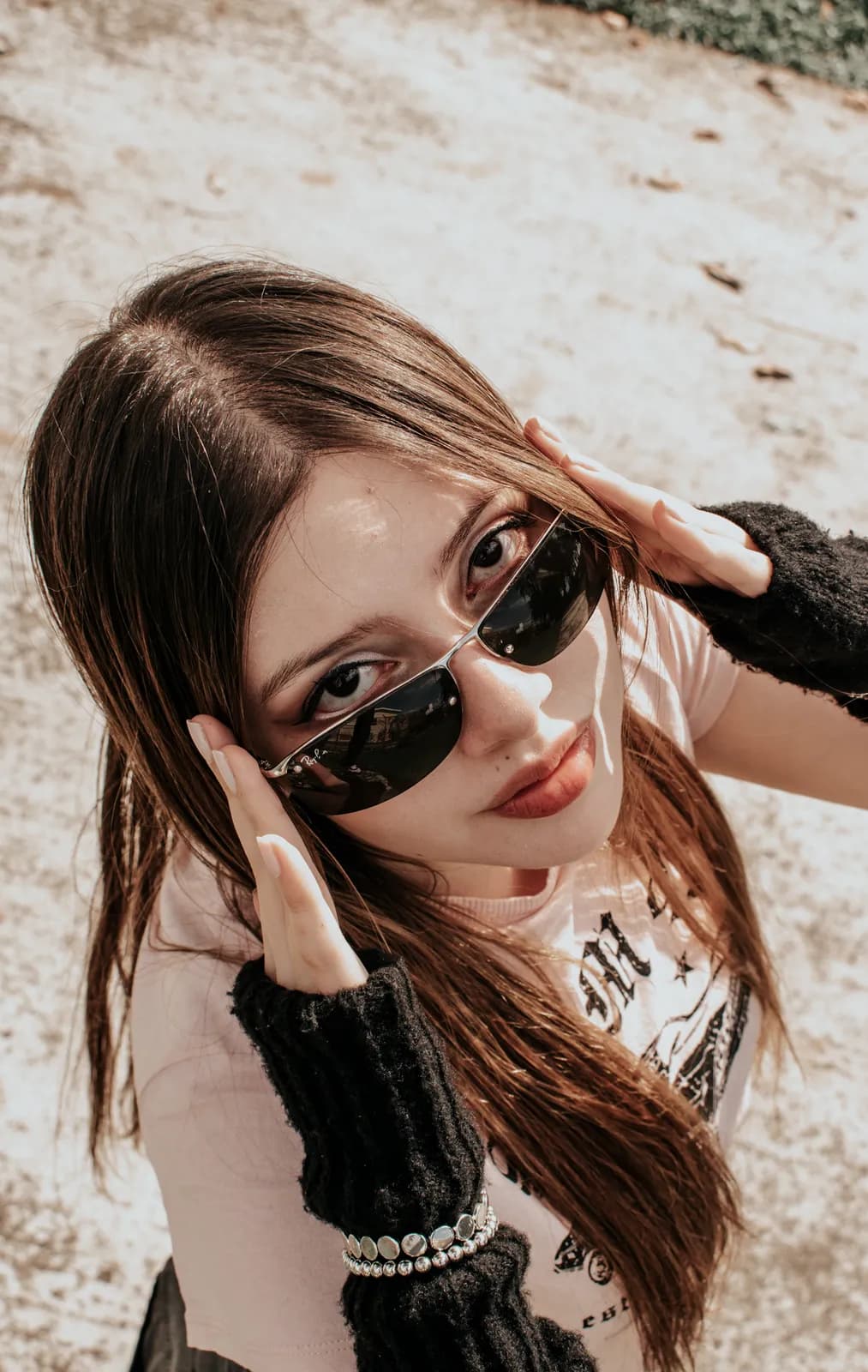 Retrato urbano de una joven con gafas de sol y guantes largos